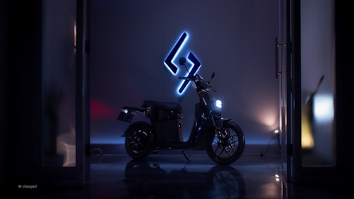 A sleek motorcycle parked outside a modern garage with warm lighting inviting riders inside.