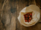Close-up of a rustic wooden table topped with fresh tomatoes and basil from local farmers.