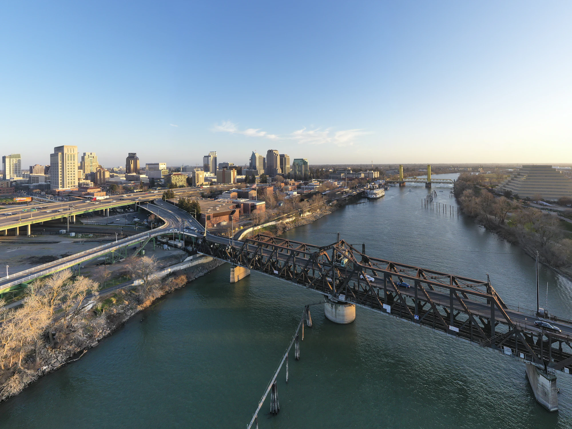 Aerial drone view of the Sacramento skyline and river under a clear blue sky