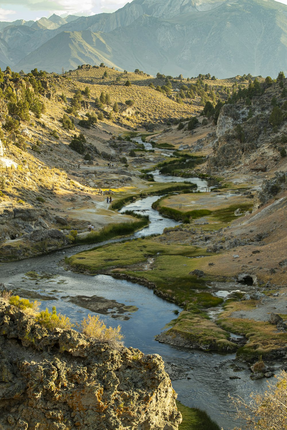 a river running through a valley surrounded by mountains