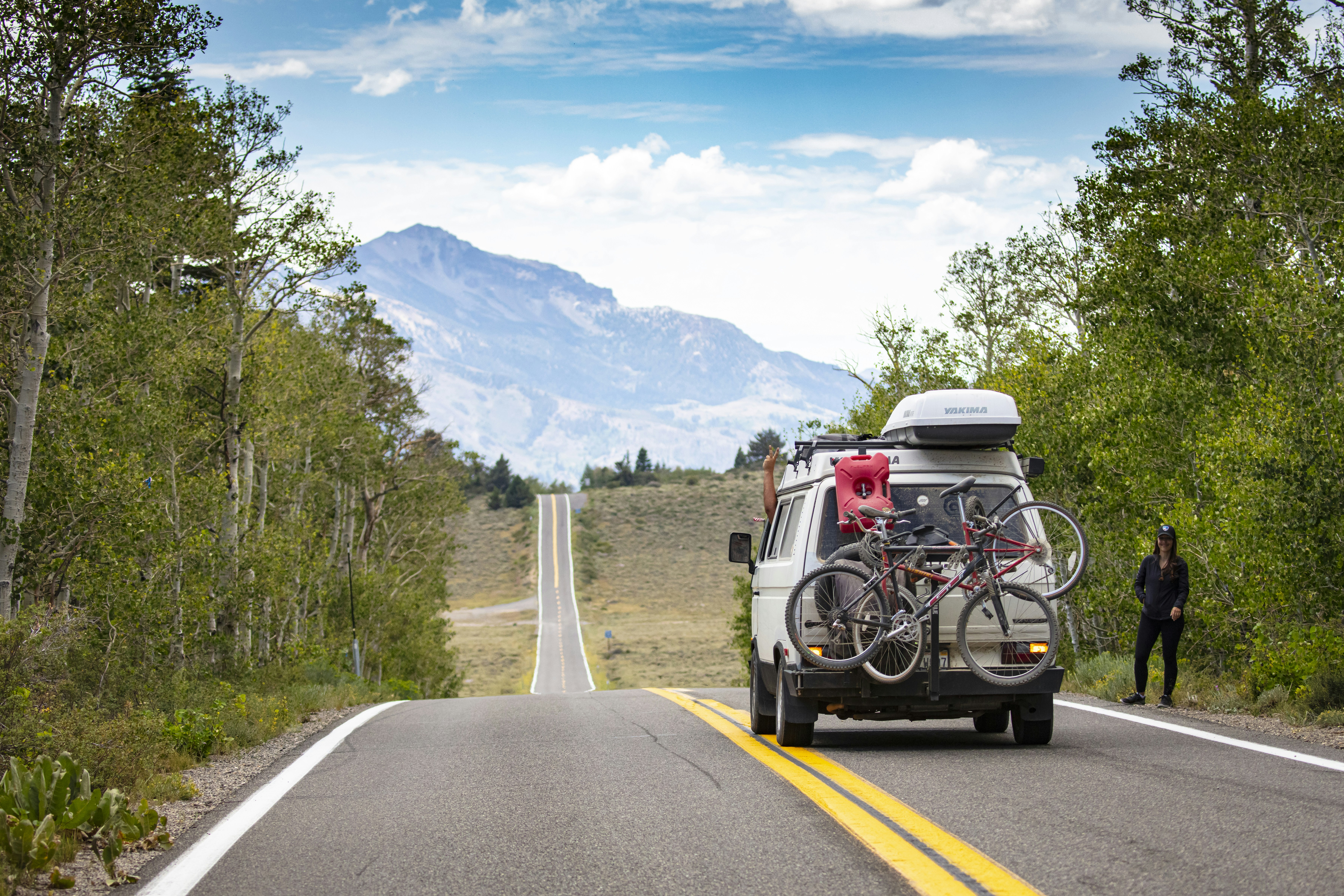 a van with bicycles on the back of it driving down a road
