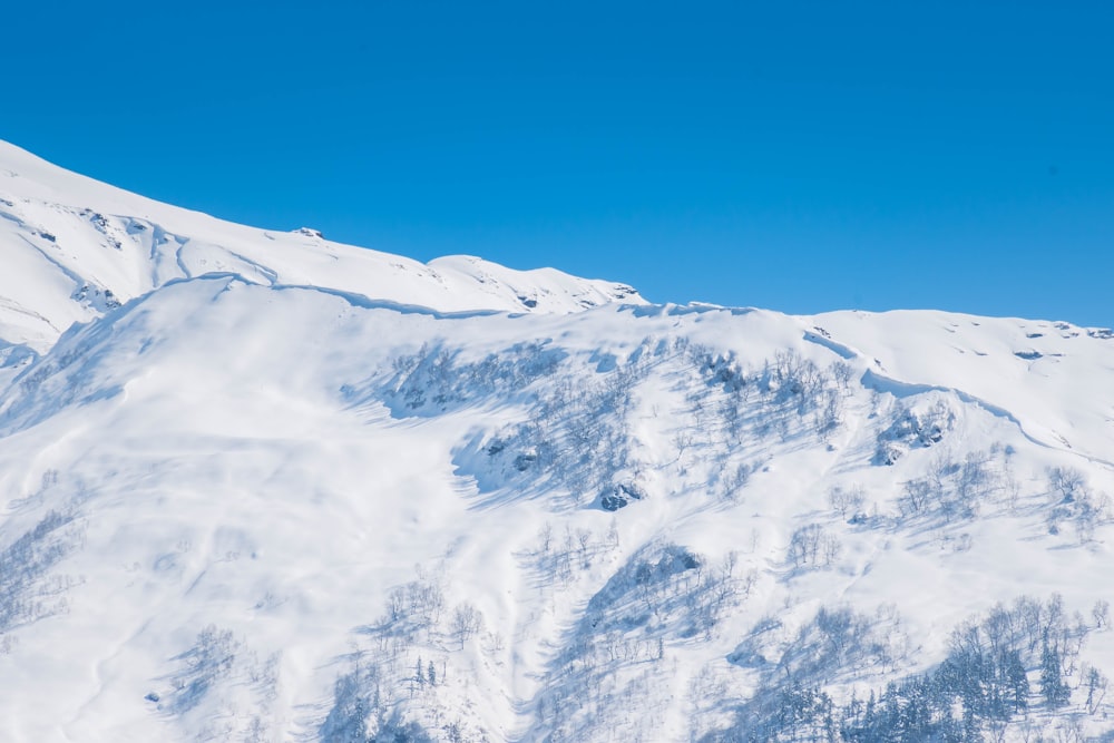 a snow covered mountain with a blue sky in the background