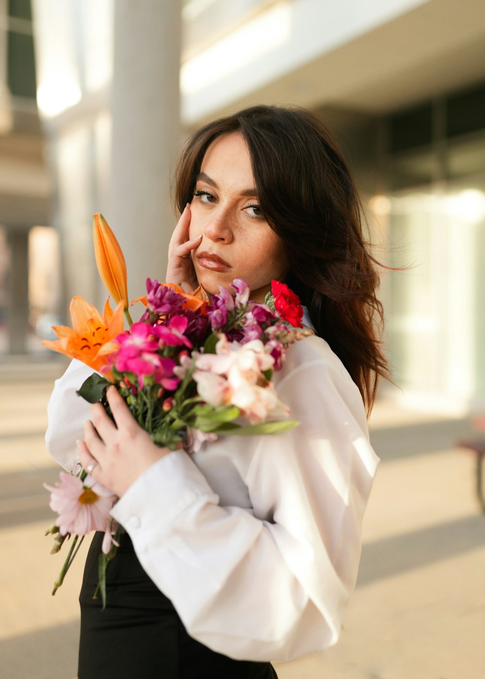 a woman is holding a bouquet of flowers