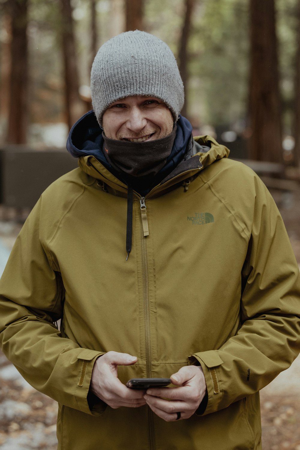 a man standing in the woods looking at his cell phone