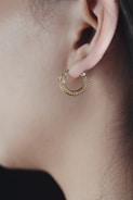 Person with a small hoop earring in the tragus, smiling comfortably.