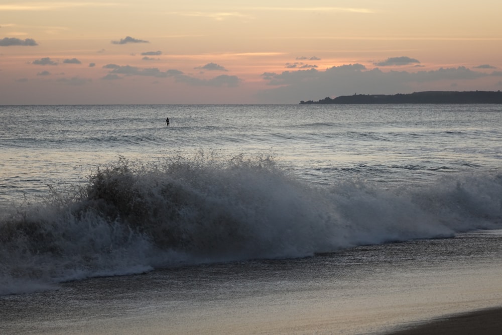 a person riding a surfboard on a wave in the ocean