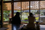 Couple enjoying a candlelit dinner on a private terrace overlooking lush greenery.