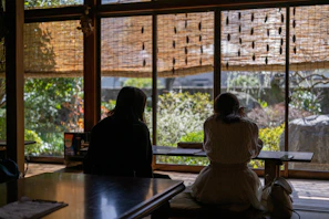 Couple enjoying a candlelit dinner on a private terrace overlooking lush greenery.