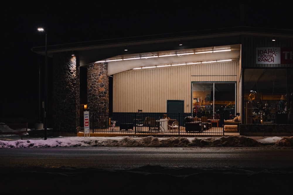 a store front at night with snow on the ground