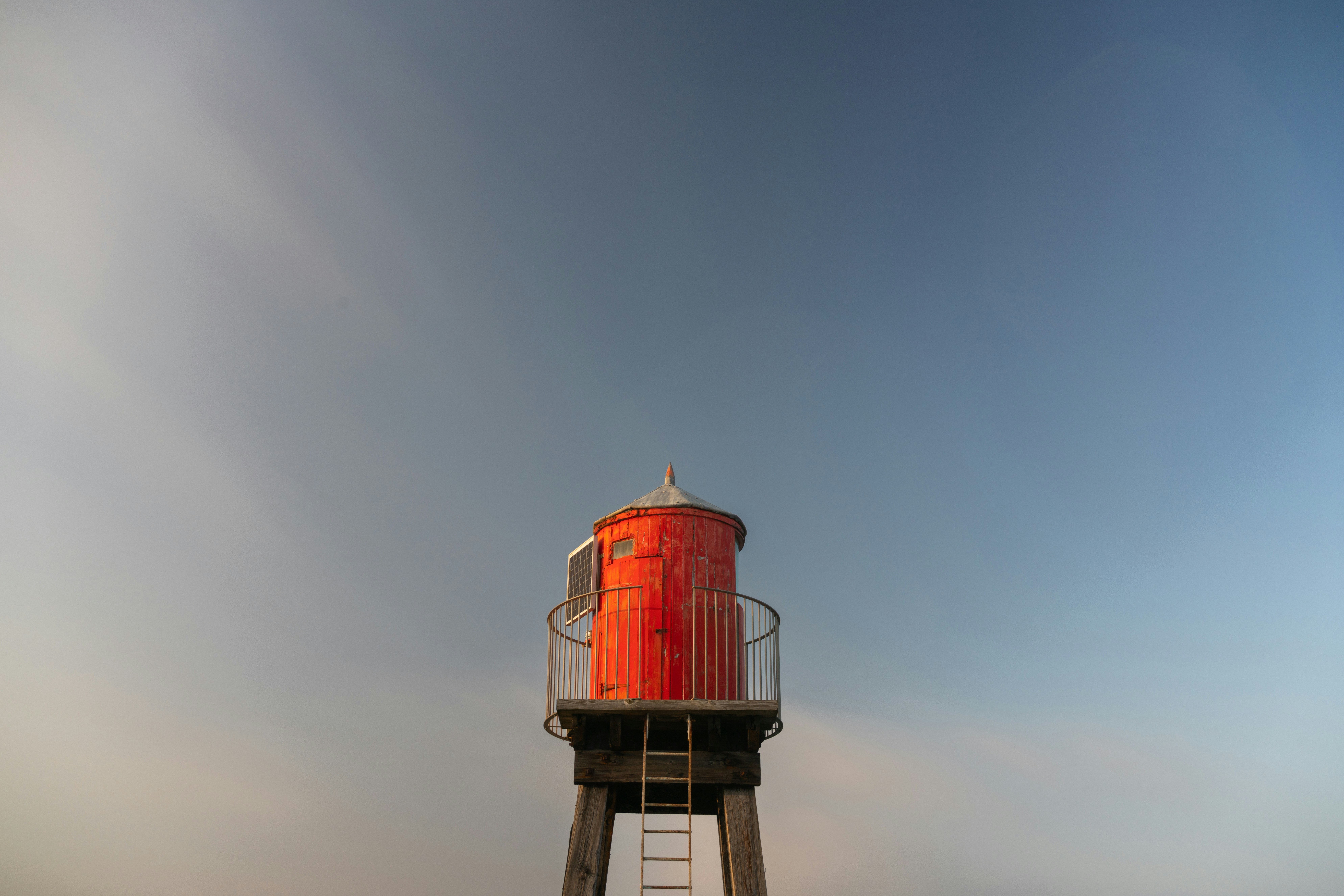 a tall red tower sitting on top of a lush green field