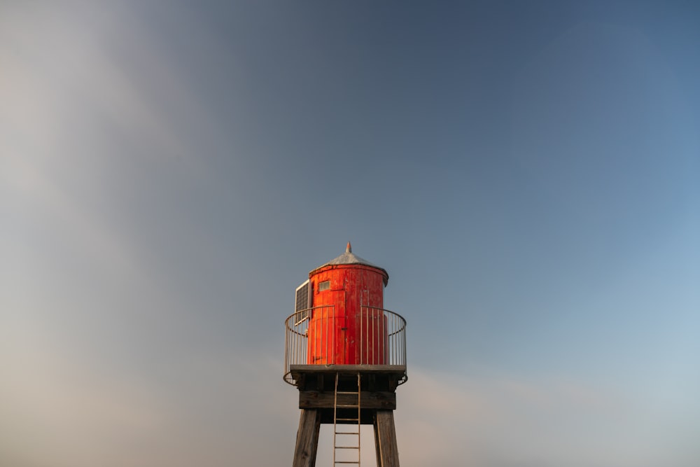 a tall red tower sitting on top of a lush green field