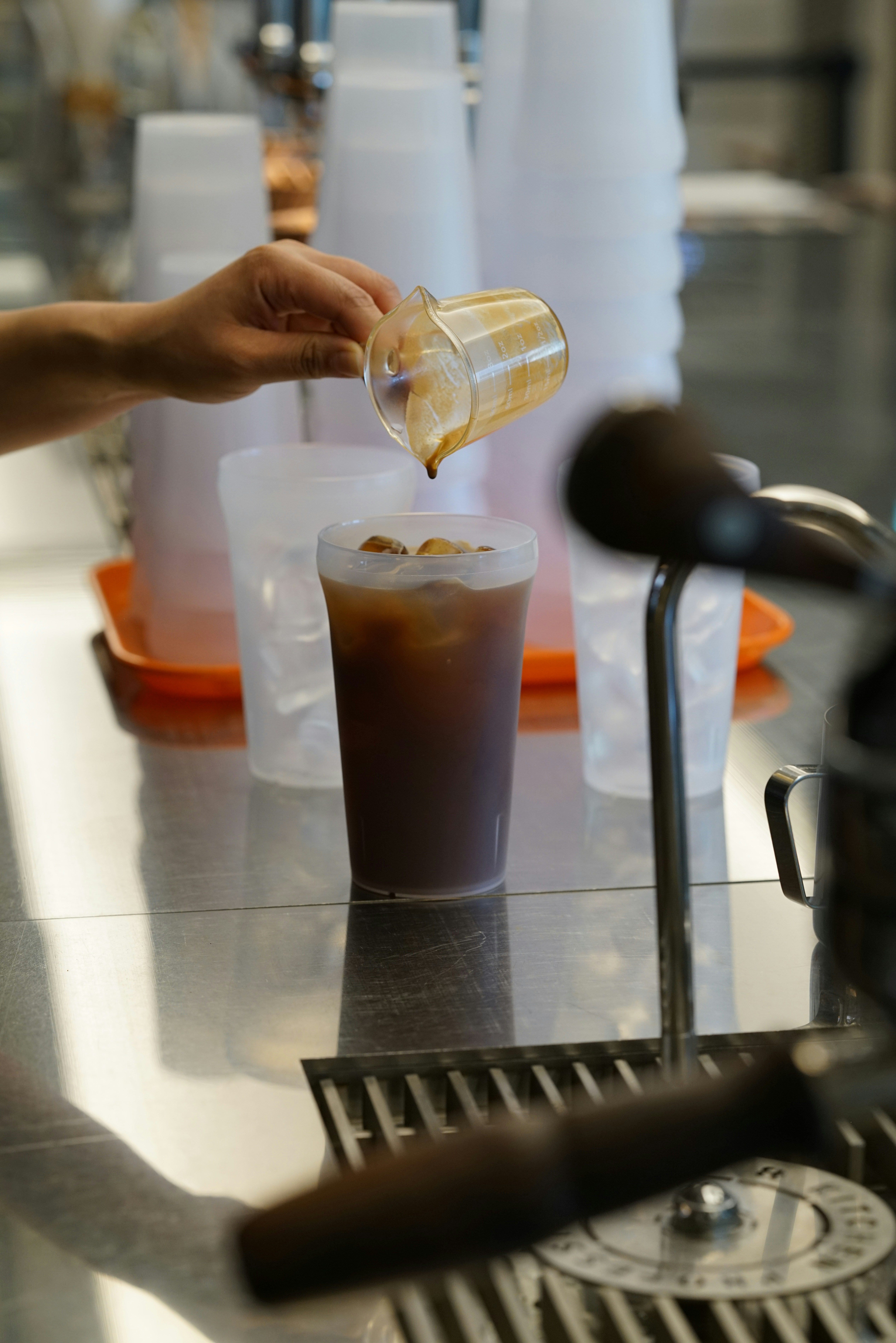 a person pours a beverage into a plastic cup