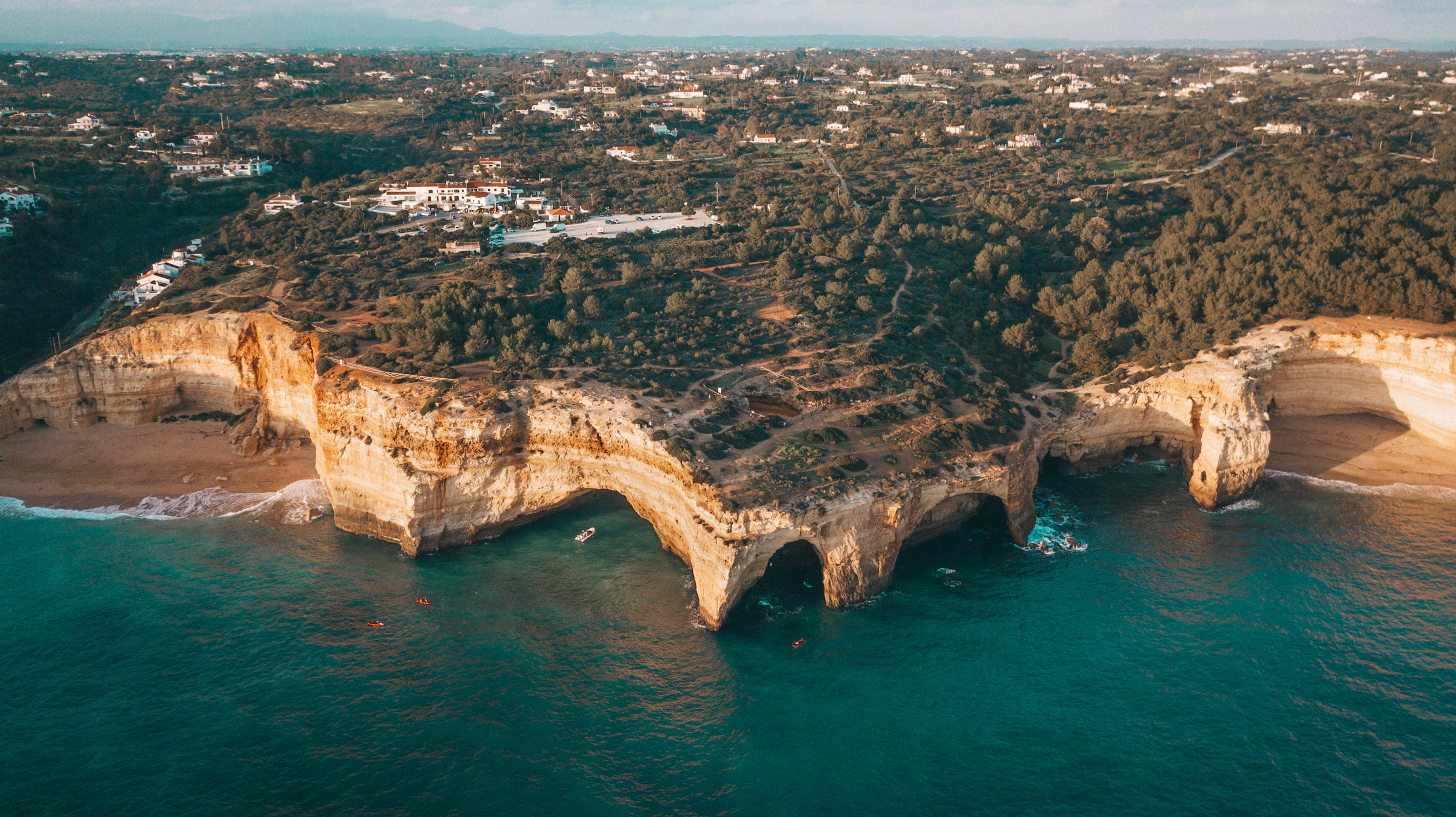 Luchtfoto van de stranden en goud-oranje kliffen van Albufeira aan de Algarve-kust, met helder turquoise water