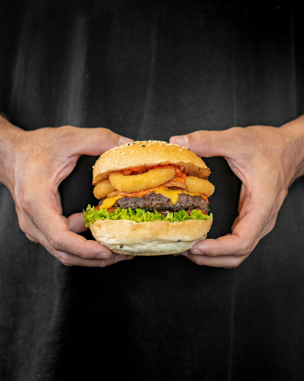 a person holding a hamburger in their hands