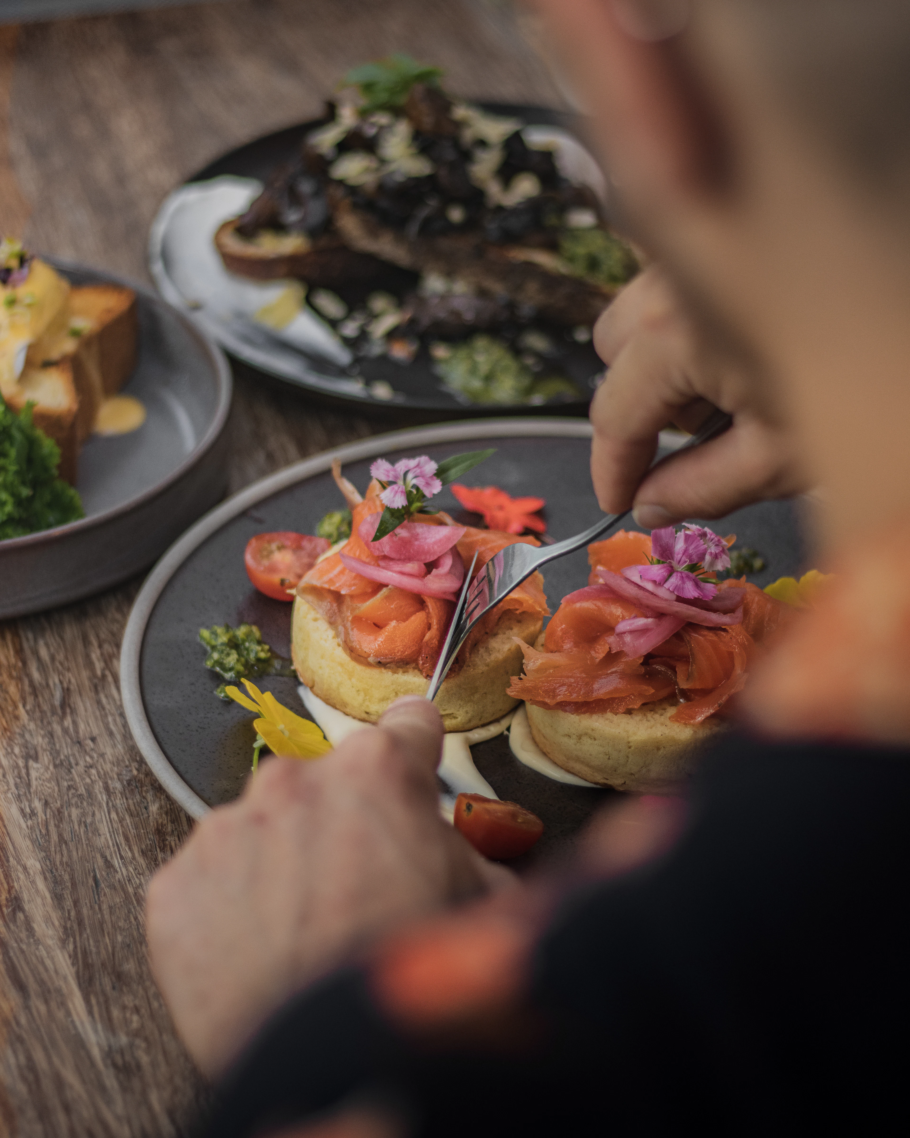 King salmon crumpets topped with cured salmon, pickled red onion, capers and edible flowers at Chuffed Cafe in Auckland CBD, New Zealand