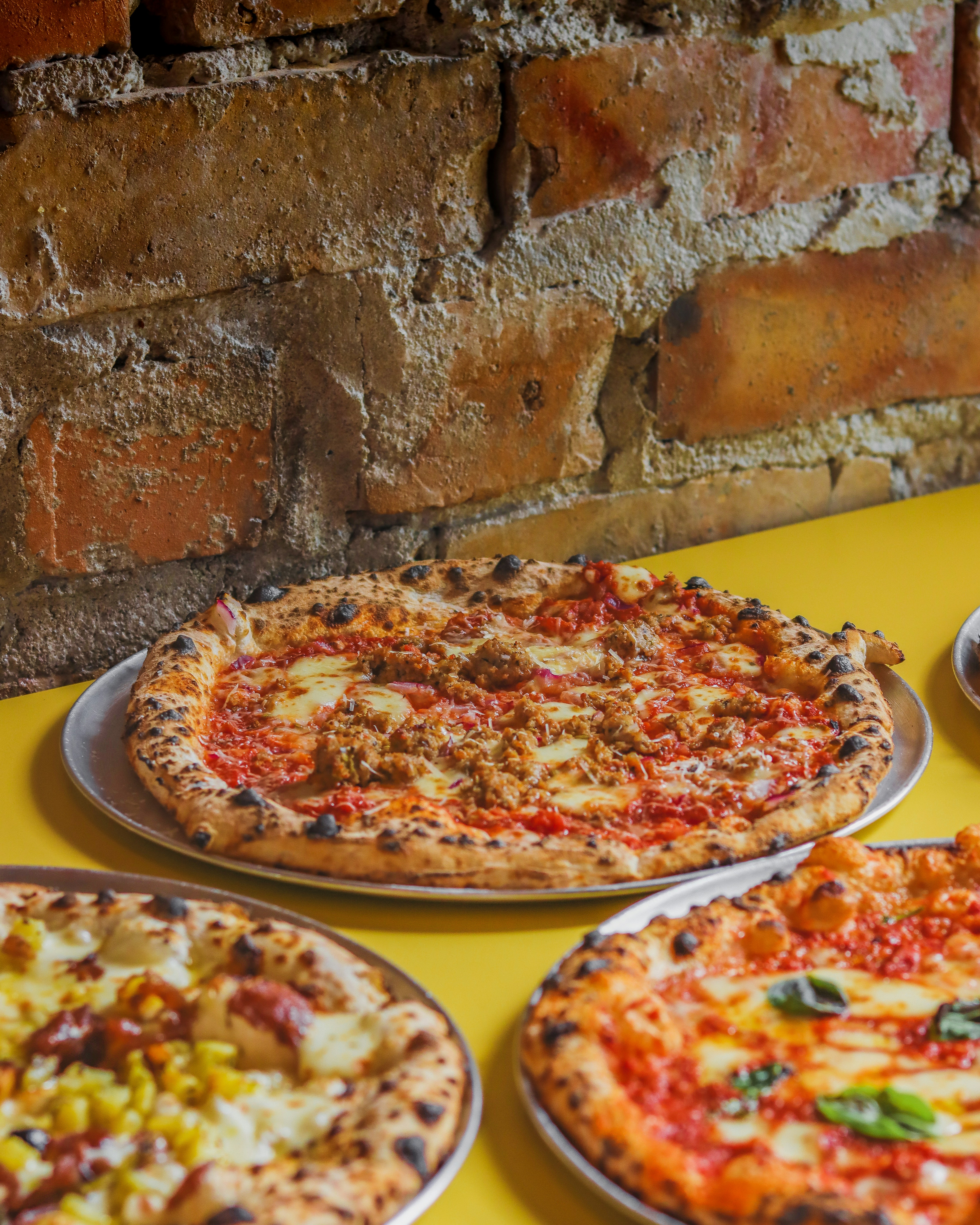 a table topped with three different types of pizza