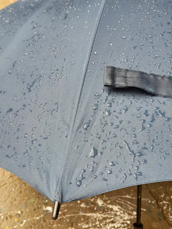 Close-up of a durable shelter fabric with rain droplets on its surface.