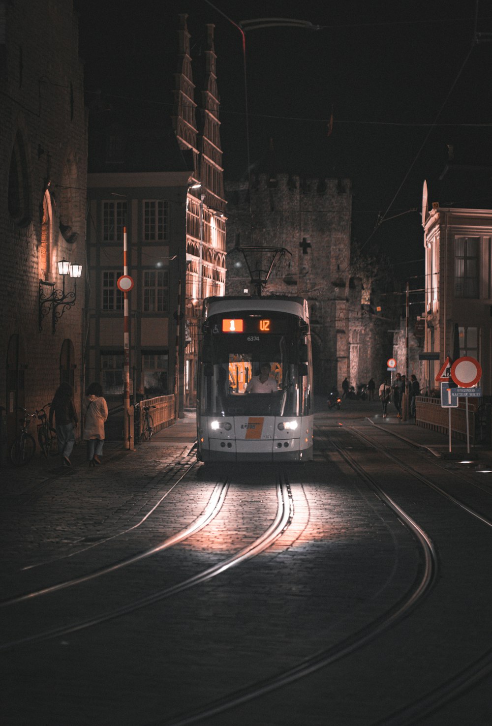 a bus driving down a street at night