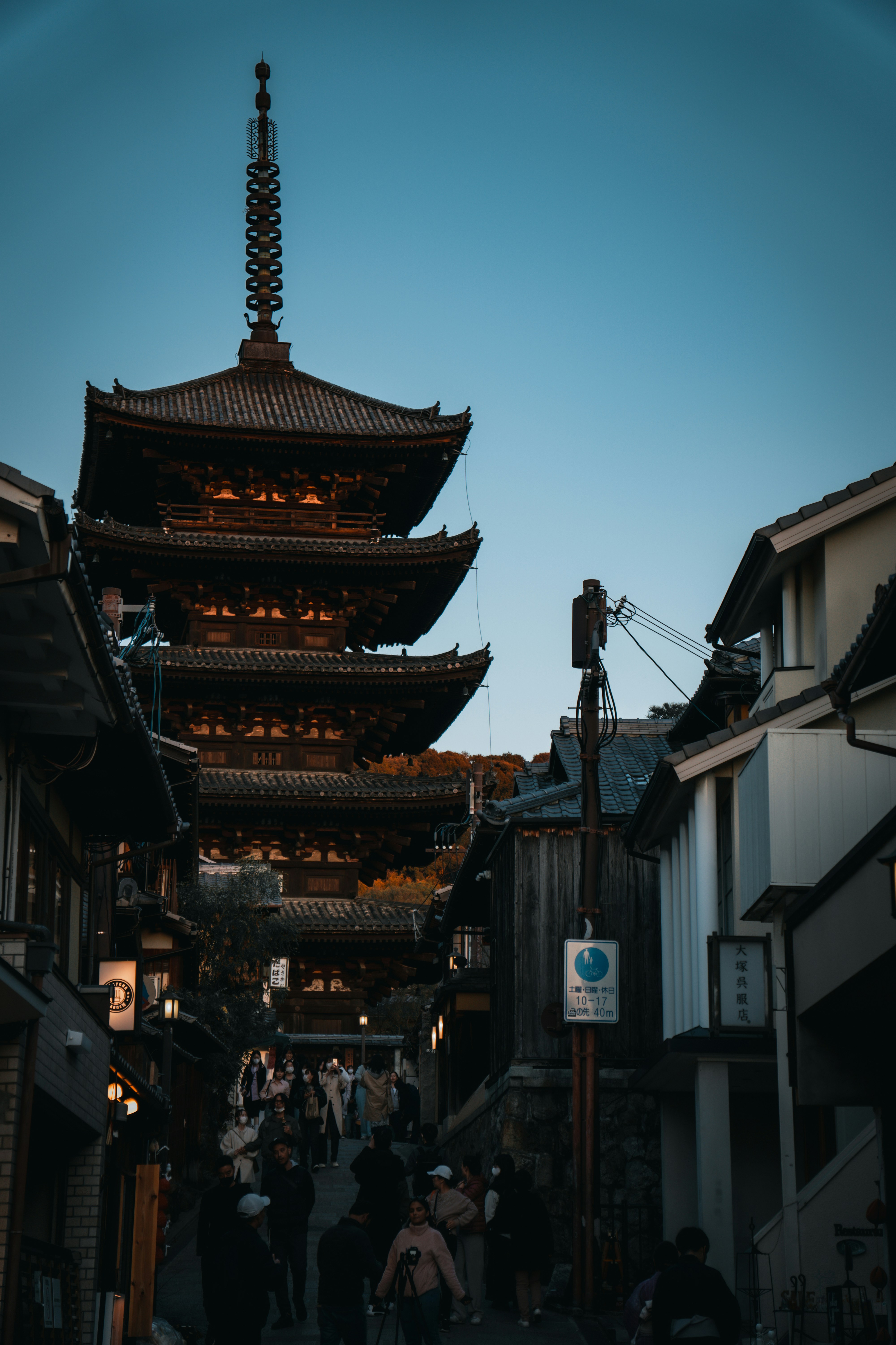 a group of people walking down a street next to tall buildings
