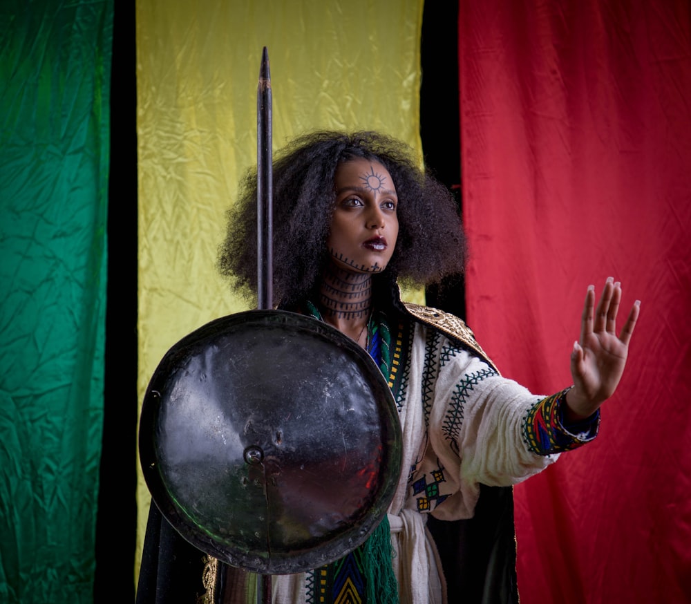 a woman dressed in a costume holding a drum