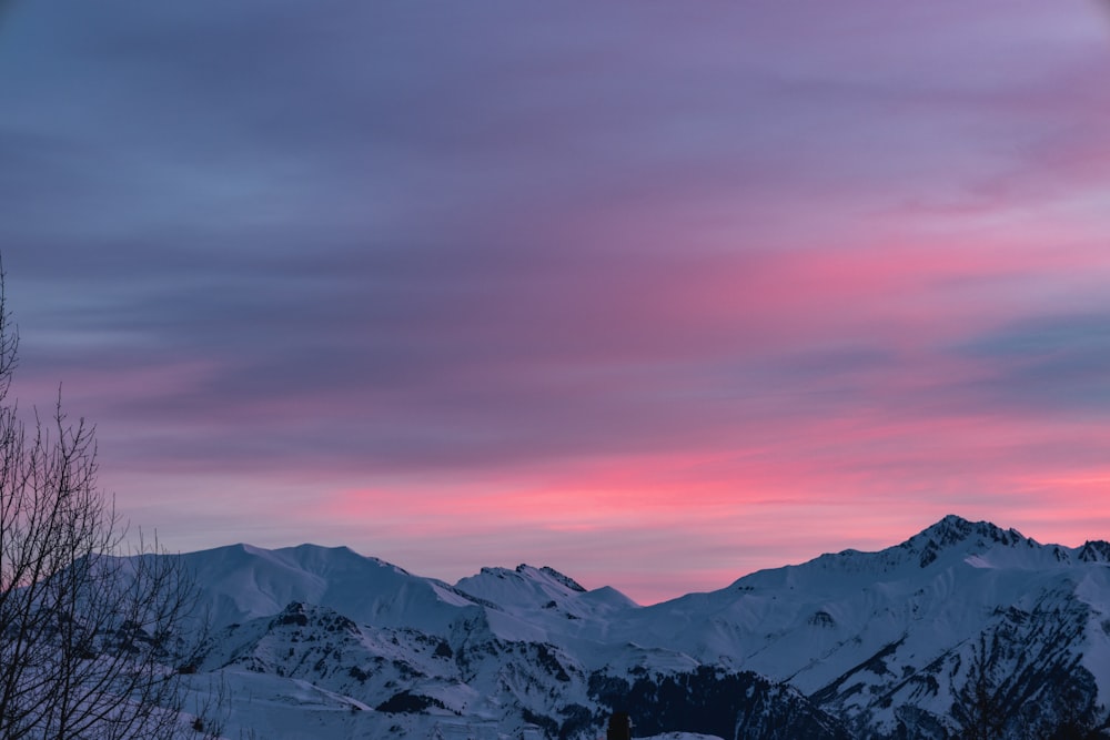 a pink and blue sky over a mountain range