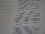 The image contains a close-up view of a page from a book with text focused on religious or philosophical content discussing gods and idols. The text appears on the right side of the page, with a margin on the left showing horizontal dotted lines.