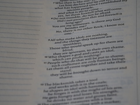 The image contains a close-up view of a page from a book with text focused on religious or philosophical content discussing gods and idols. The text appears on the right side of the page, with a margin on the left showing horizontal dotted lines.