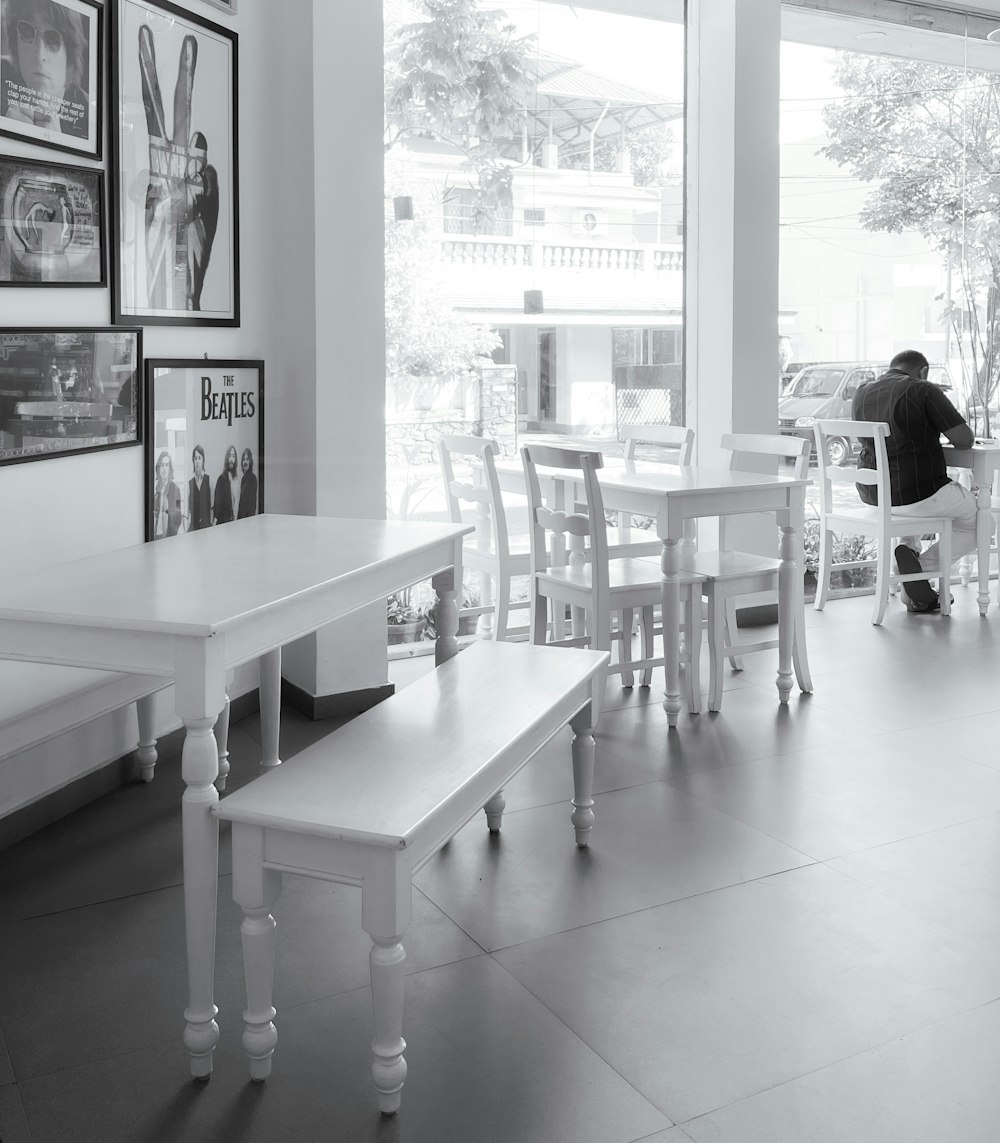 a black and white photo of a person sitting at a table
