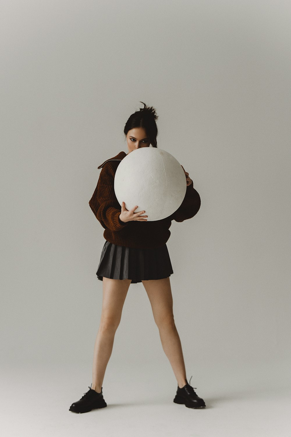a woman holding a large white ball in her hands