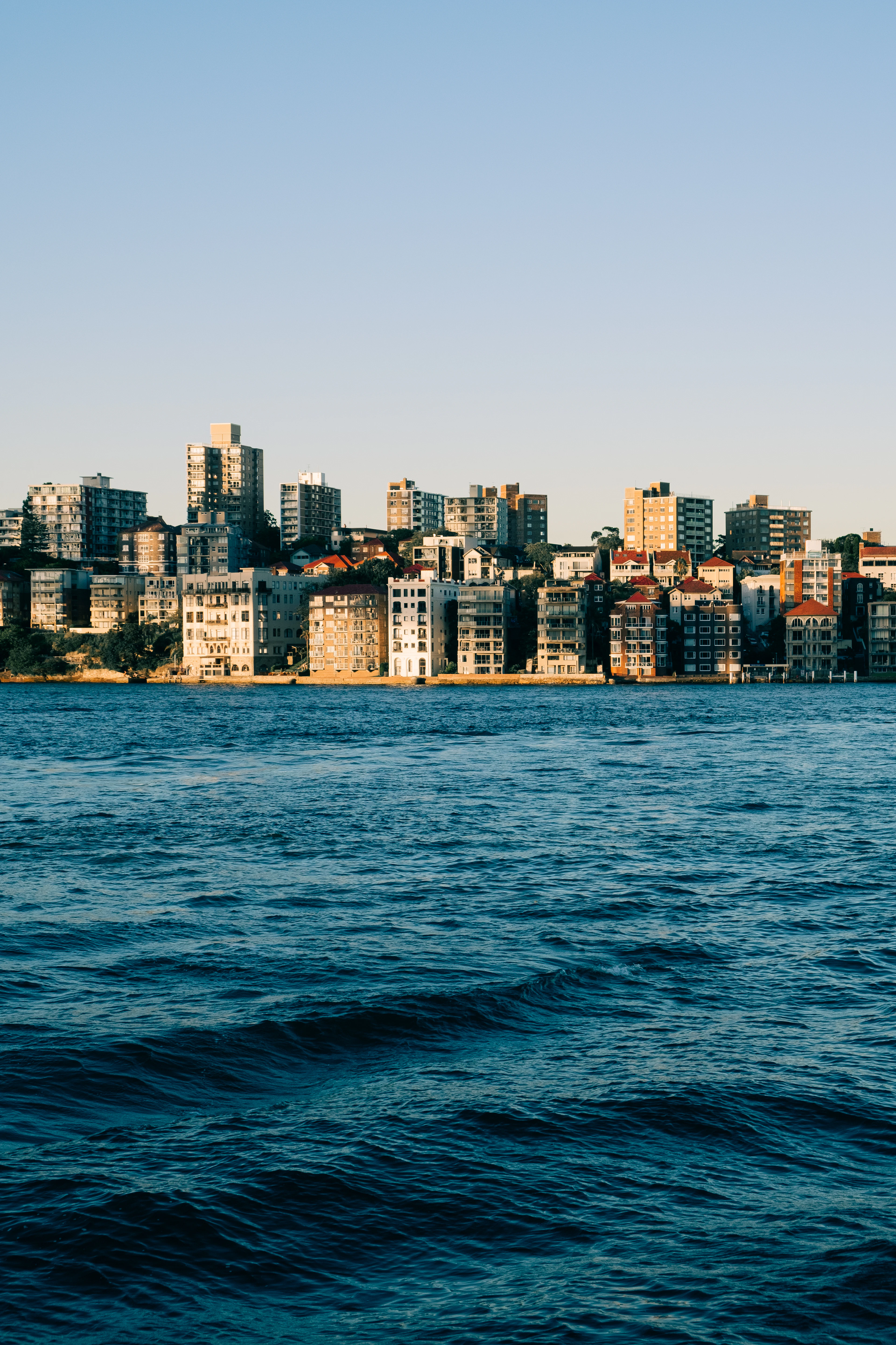 Sydney skyline viewed across choppy blue harbour water