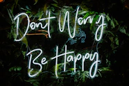 a neon sign that says don't worry be happy