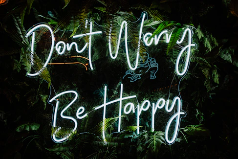 a neon sign that says don't worry be happy