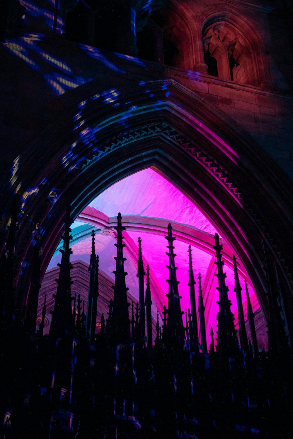 a cathedral with a pink and blue light in the background