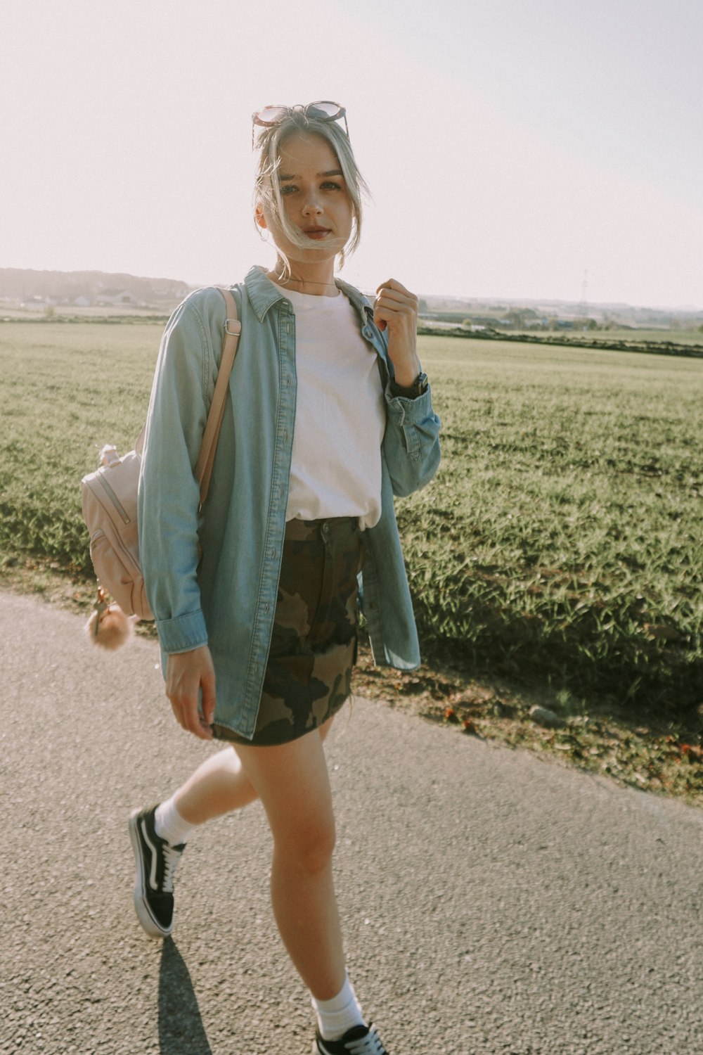 a woman walking down a road with a backpack