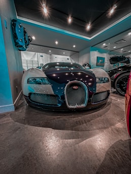Interior view of a modern infrared paint curing room with glowing red lights and a luxury car inside.
