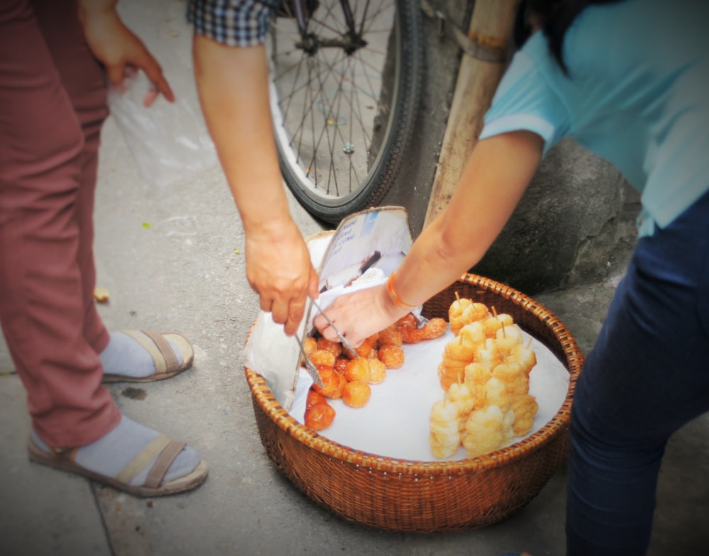 a person cutting up food in a basket