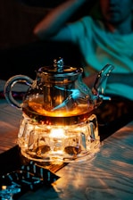 a glass tea pot with a light inside of it
