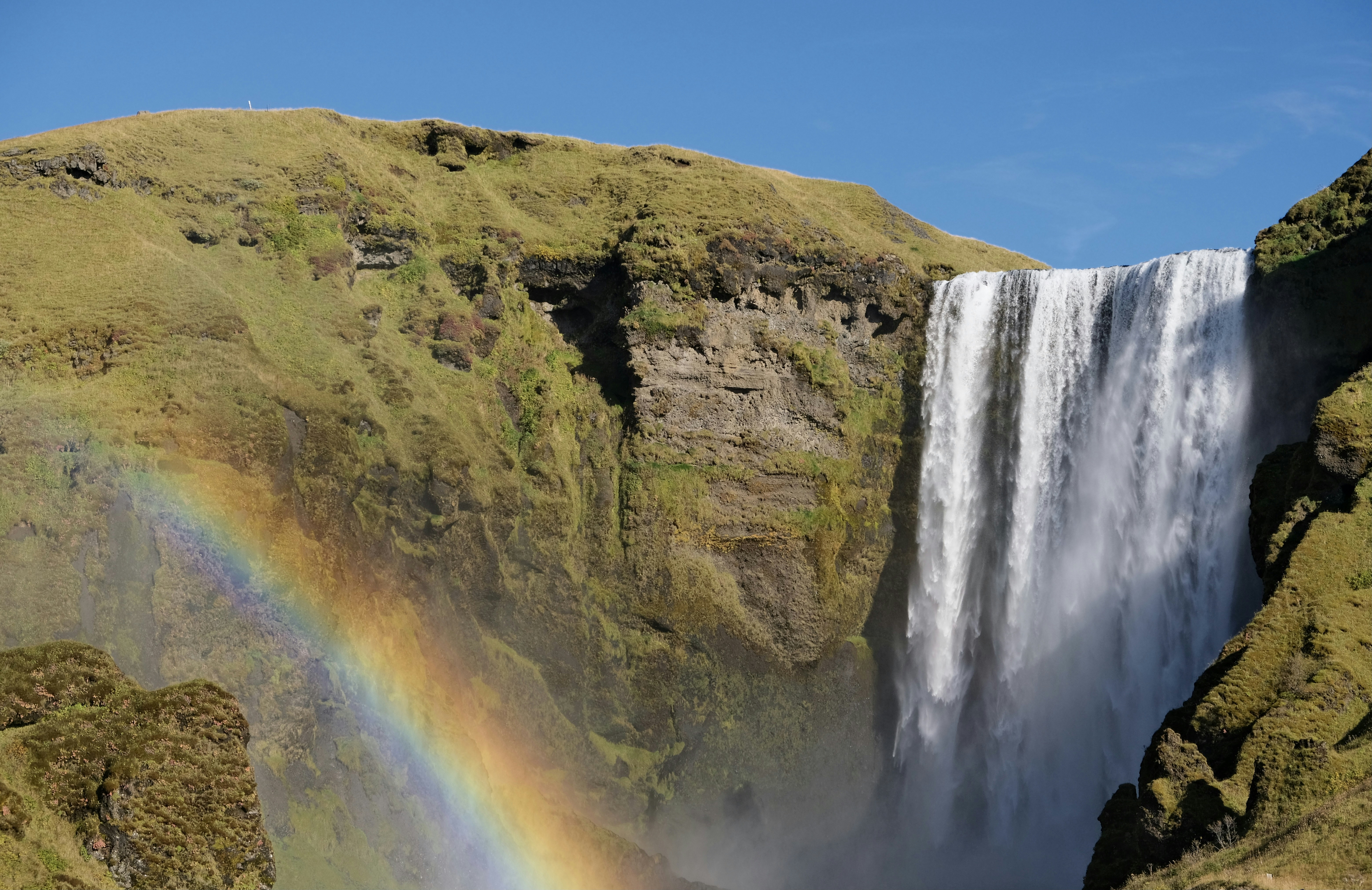 Una cascada con un arco iris en medio de ella