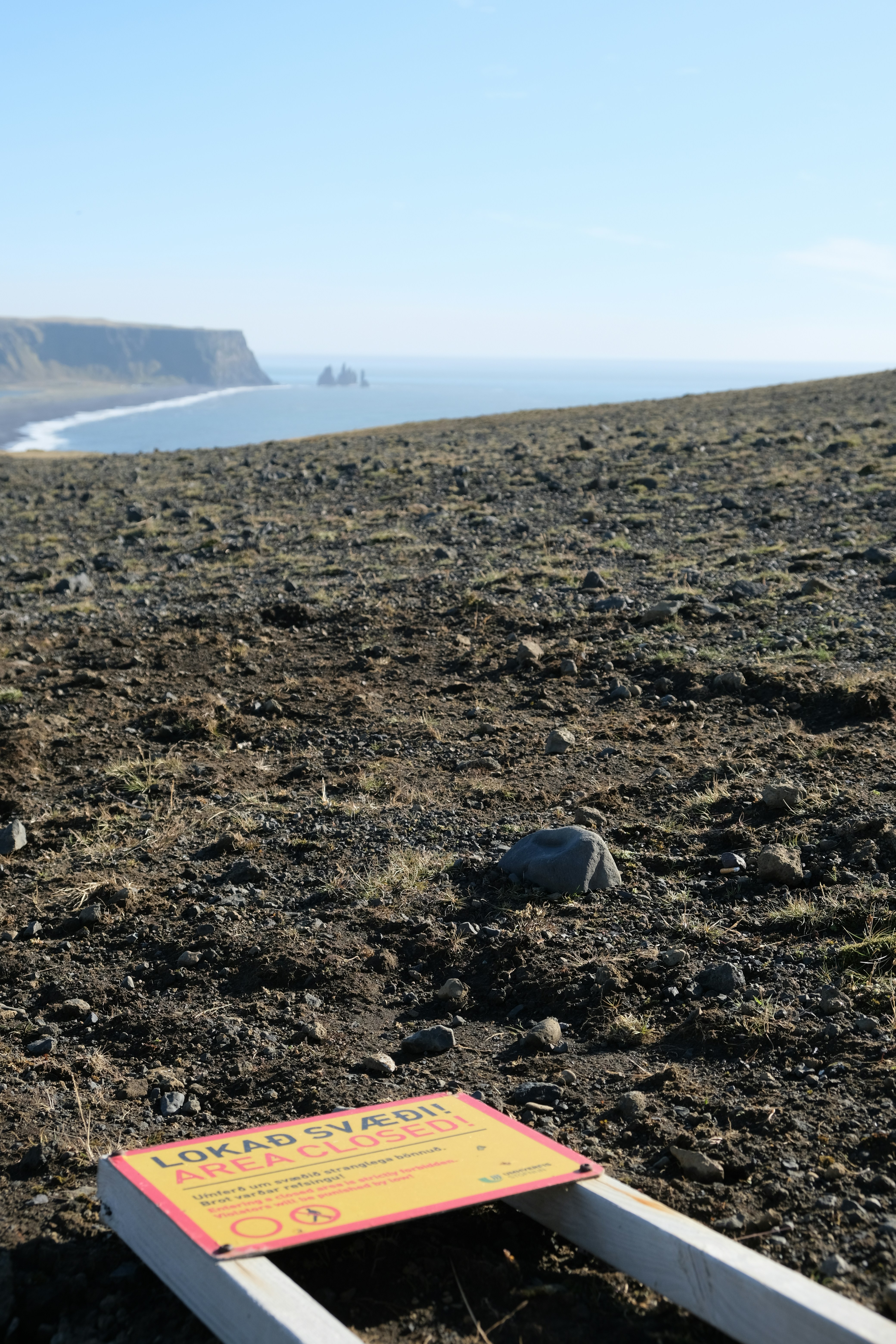 Un letrero sentado en la parte superior de un campo de tierra