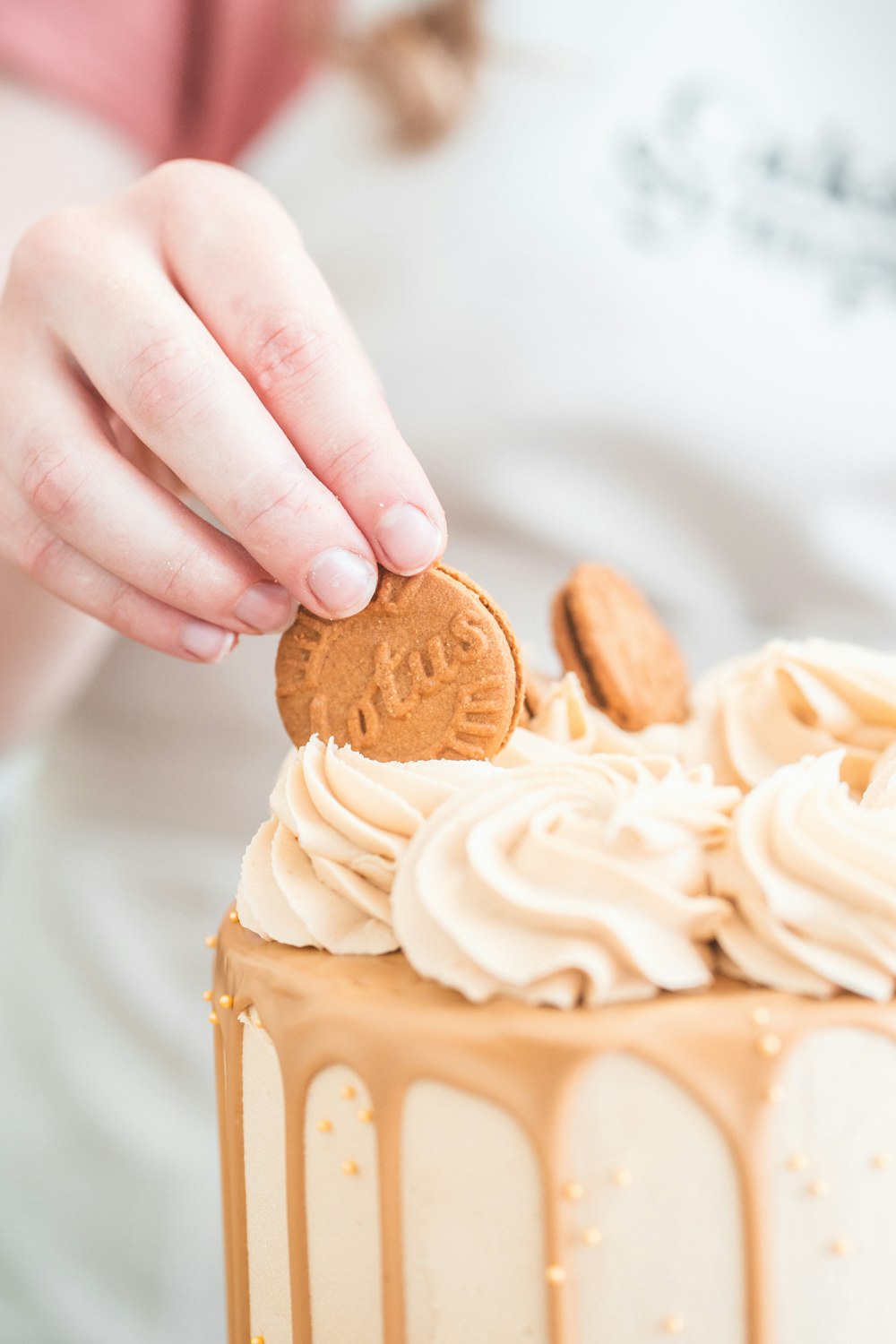 a person putting a cookie on top of a cake