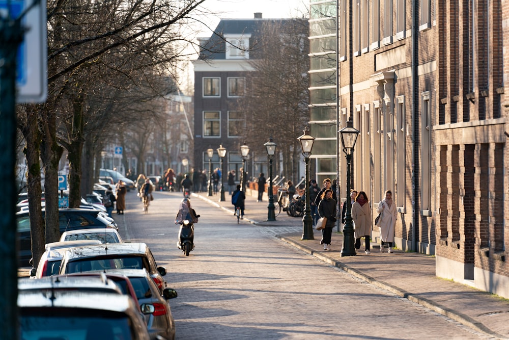 a group of people walking down a street next to tall buildings