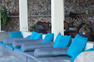 A tranquil corner of the salon with natural stone planters and soft beige cushions, inviting relaxation.