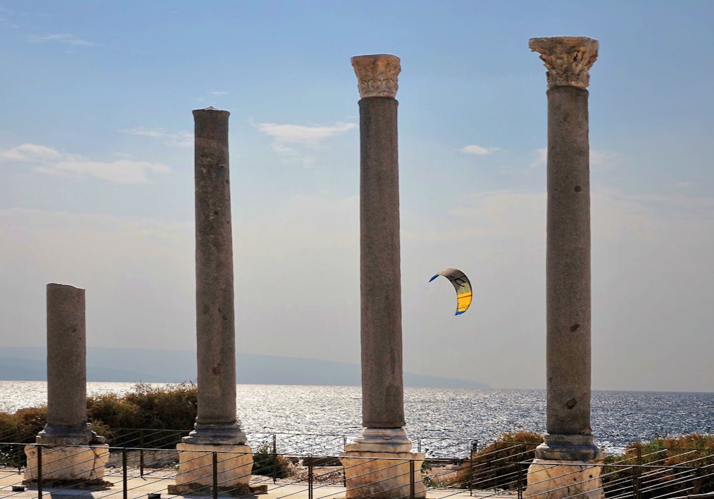 a kite is being flown between two stone pillars