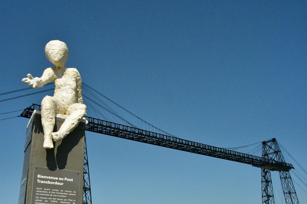 a statue of a man sitting on top of a cement block