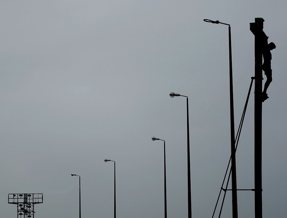 Un hombre está en un poste de luz de la calle