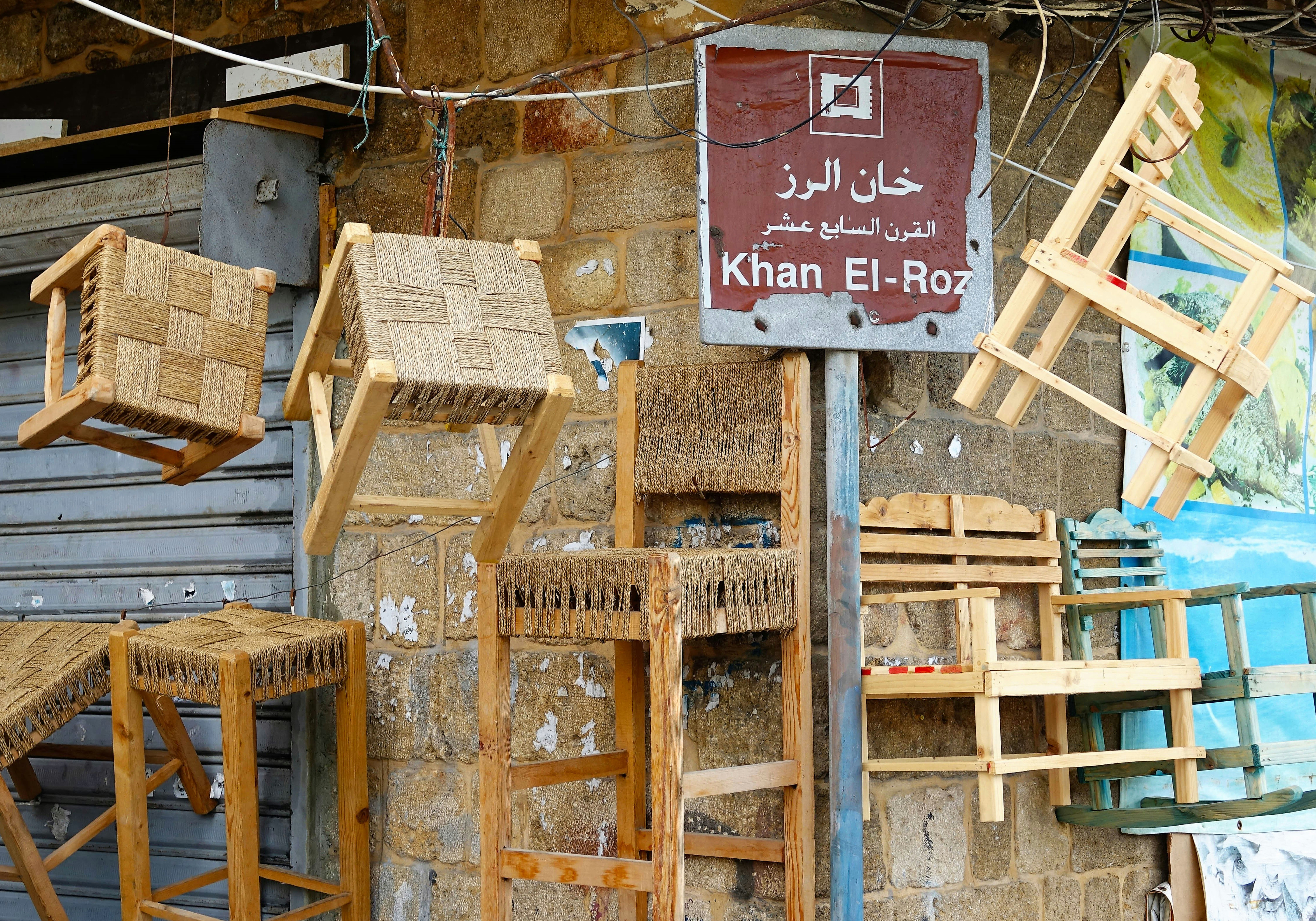 a bunch of wooden chairs hanging on a wall