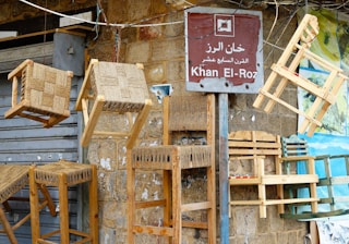 a bunch of wooden chairs hanging on a wall