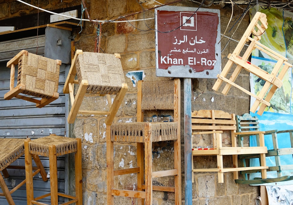 a bunch of wooden chairs hanging on a wall