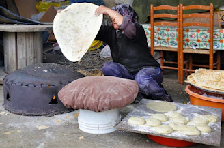 Artisan hands shaping traditional barley flatbread in a rustic kitchen setting.