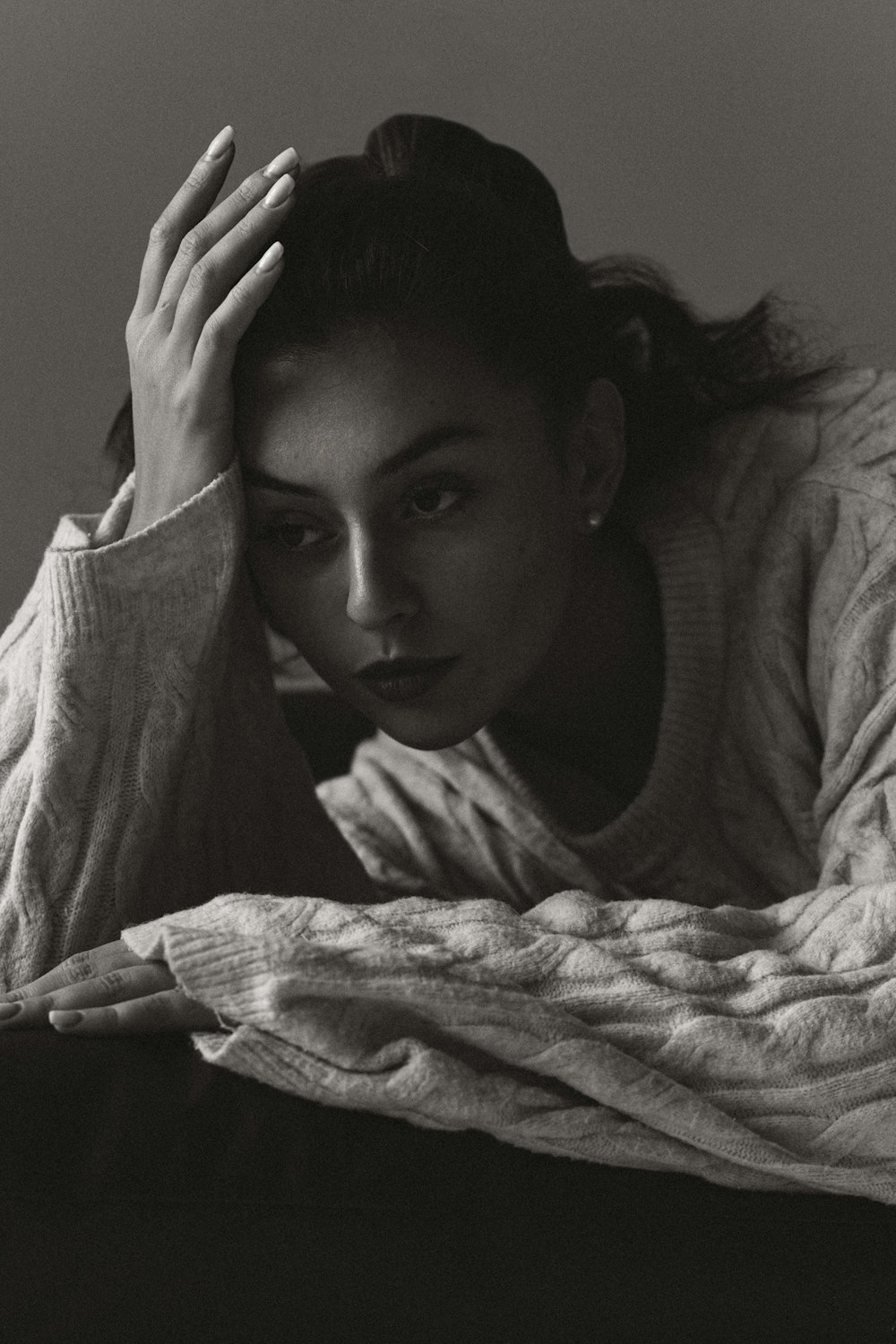 a black and white photo of a woman laying on a bed